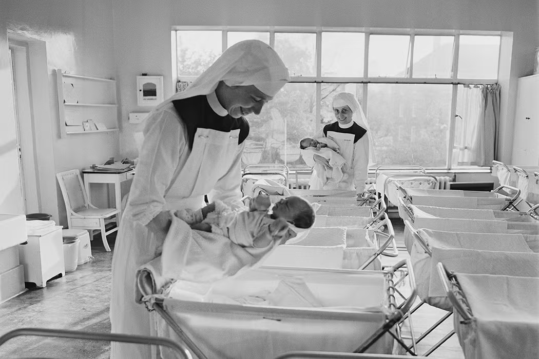 Dos monjas sosteniendo bebés en una casa de maternidad